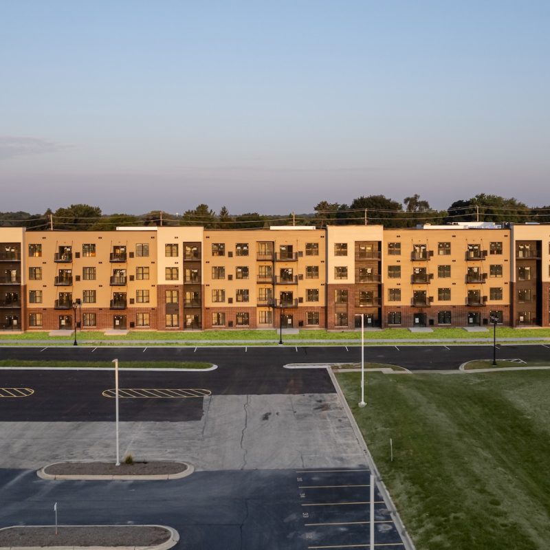 Station 250 apartment complex exterior at dusk showing illuminated windows and modern architecture in Mundelein IL
