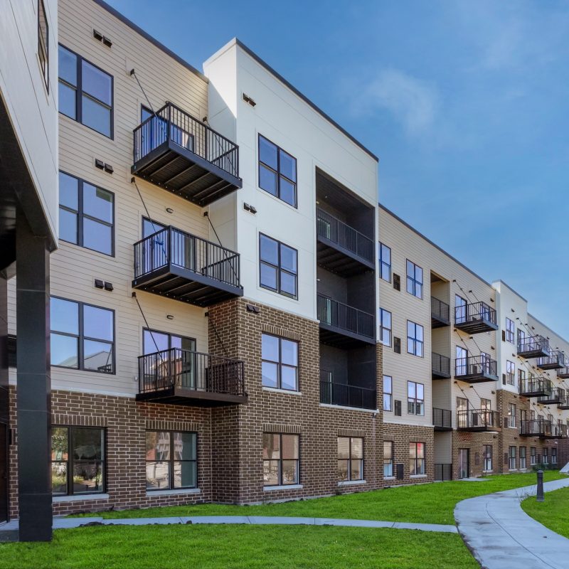 Station 250 apartment building with landscaped green lawn area and contemporary brick facade in Mundelein IL