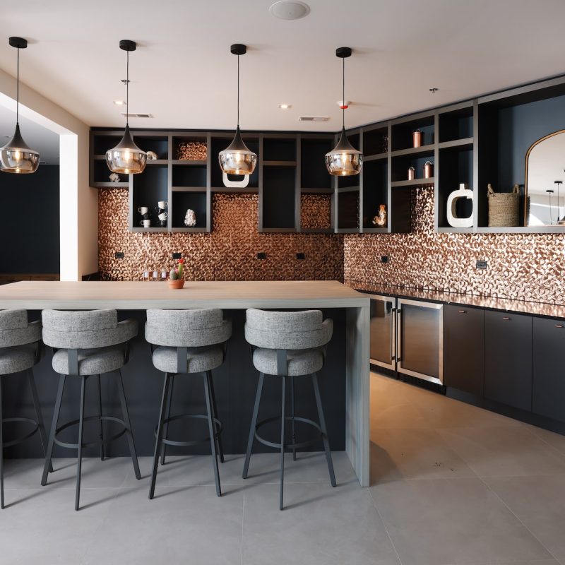 Modern resident lounge with contemporary seating, warm lighting, and wood accents at Station 250 Mundelein apartments