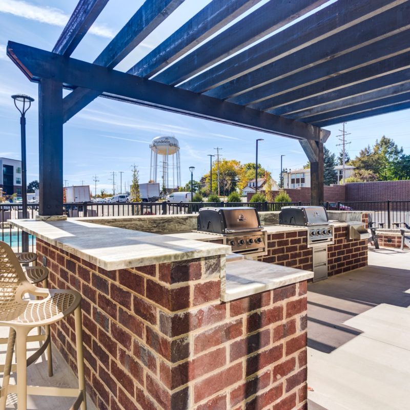 Station 250 outdoor terrace and grilling station with wooden benches, concrete deck,.