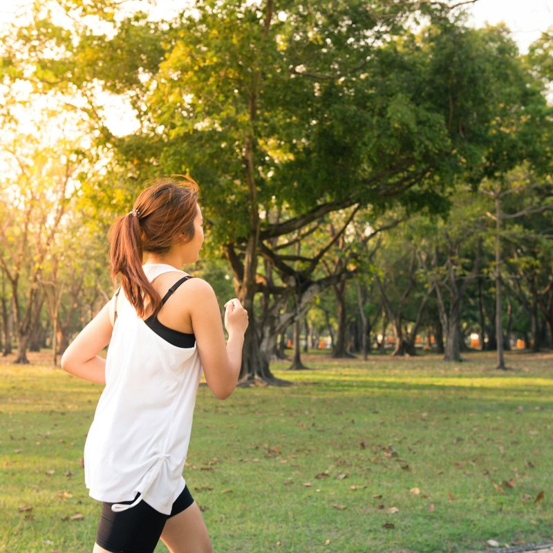 Woman running on scenic trail near Mundelein Illinois showcasing outdoor recreation opportunities for Station 250 apartment residents